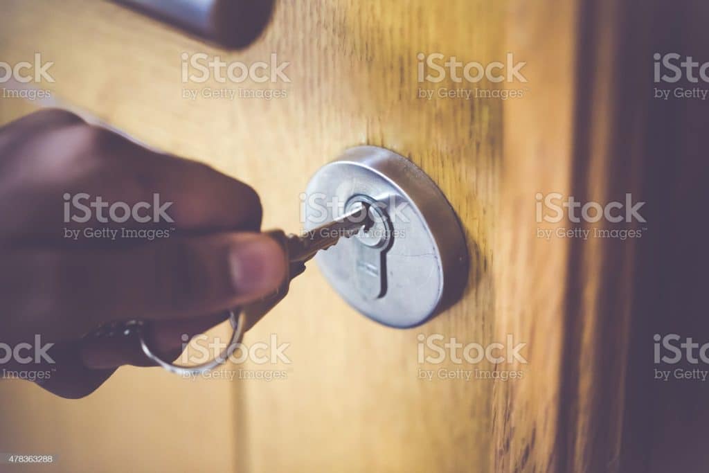Man unlocking the door of his home.